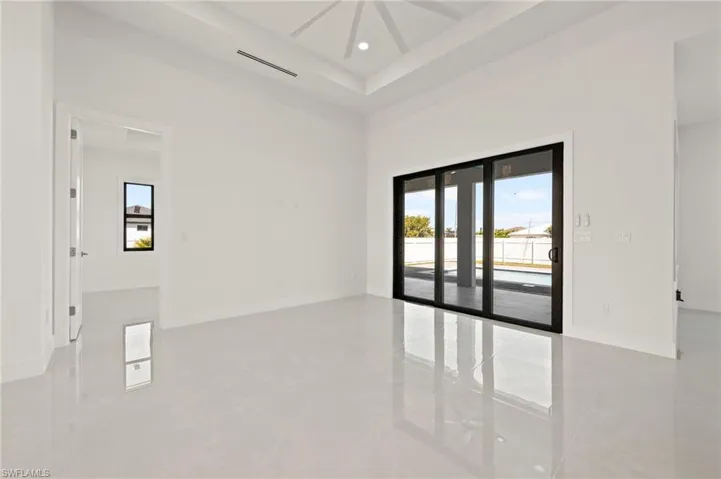 Unfurnished room with a towering ceiling, recessed lighting, baseboards, and french doors