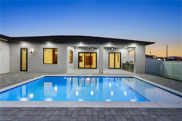 Pool at dusk with a patio area, fence, a ceiling fan, and a fenced in pool