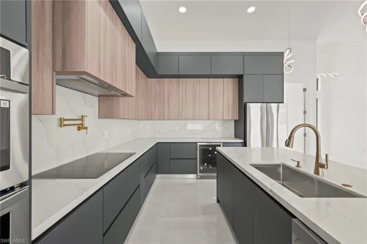 Kitchen featuring wine cooler, gray cabinetry, stainless steel appliances, a sink, and modern cabinets