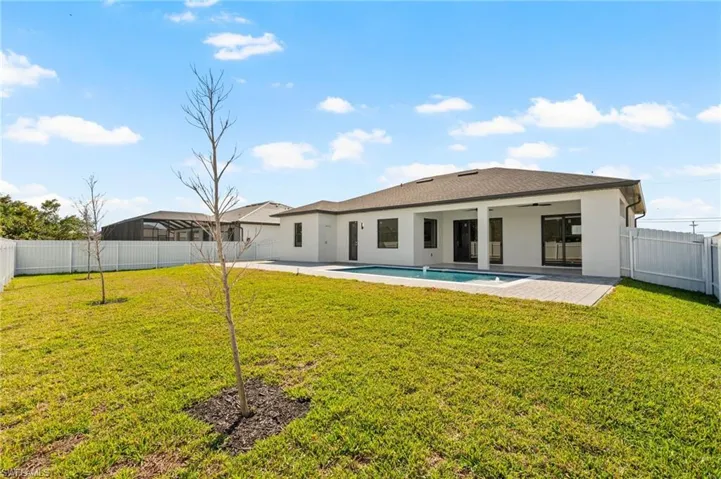 Rear view of house featuring a yard, a patio area, and a fenced backyard