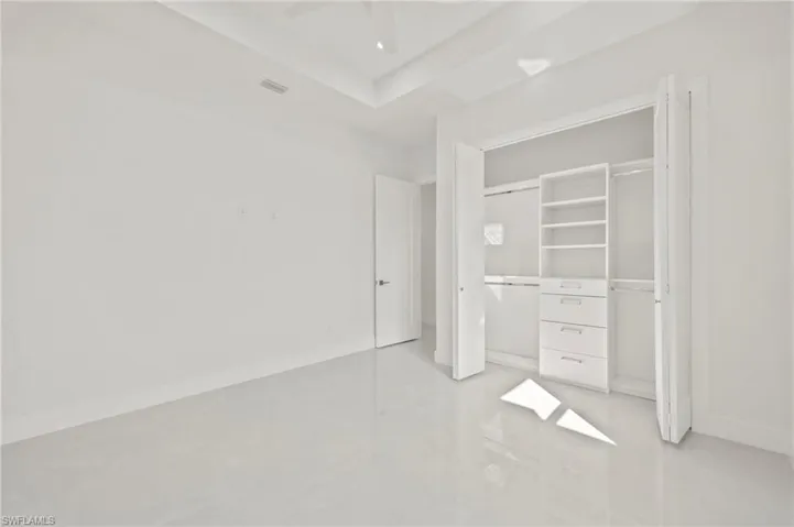 Unfurnished bedroom featuring visible vents, baseboards, ceiling fan, and a closet