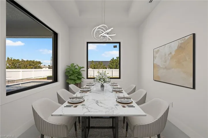 Dining area with a chandelier, a tray ceiling, and baseboards