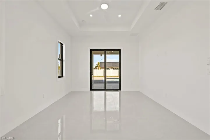 Unfurnished room featuring visible vents, baseboards, a raised ceiling, a ceiling fan, and recessed lighting