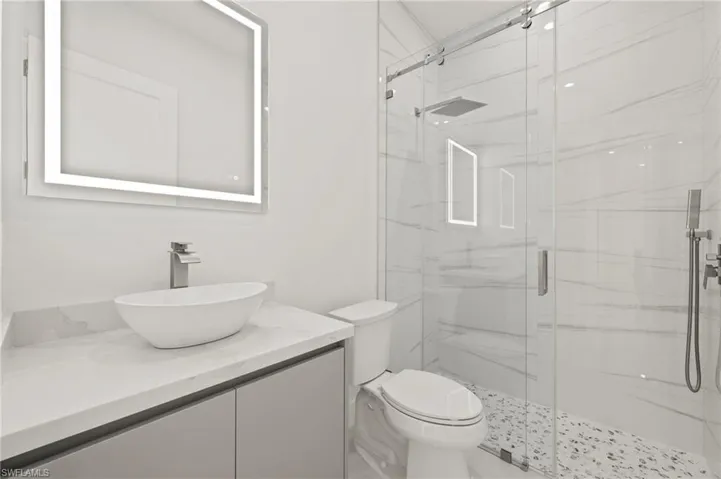 Full bathroom with toilet, a marble finish shower, and vanity