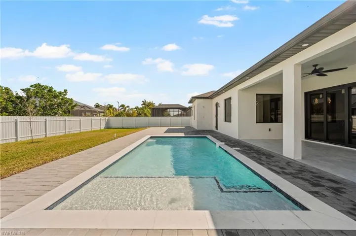 View of pool with a fenced in pool, a ceiling fan, a lawn, a fenced backyard, and a patio area