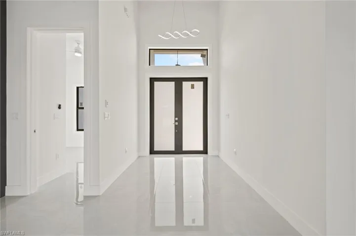 Foyer entrance featuring baseboards, a chandelier, and french doors