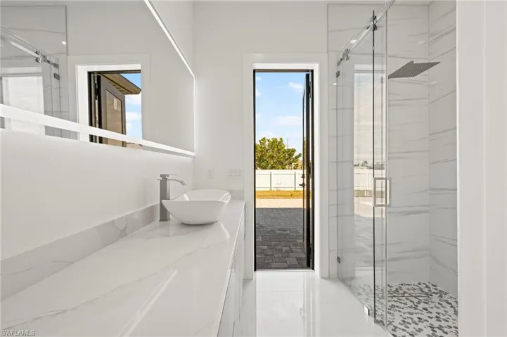 Full bathroom featuring a marble finish shower and vanity