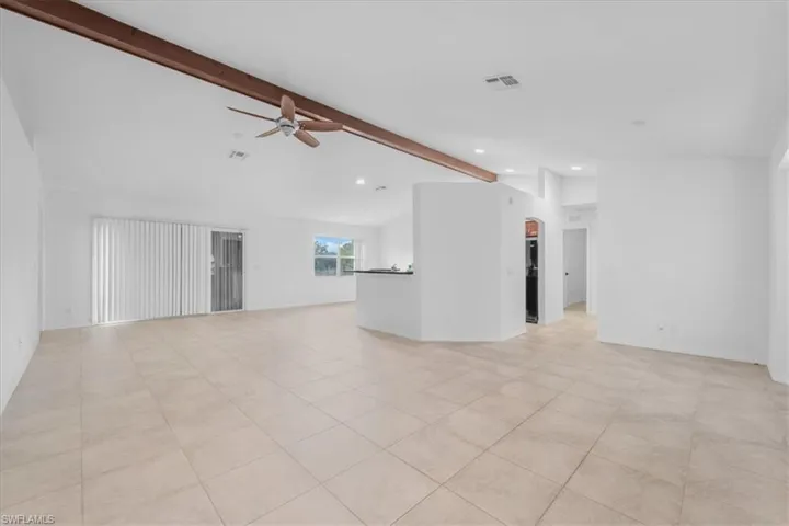 Unfurnished living room featuring ceiling fan, vaulted ceiling with beams, recessed lighting, and light tile patterned flooring