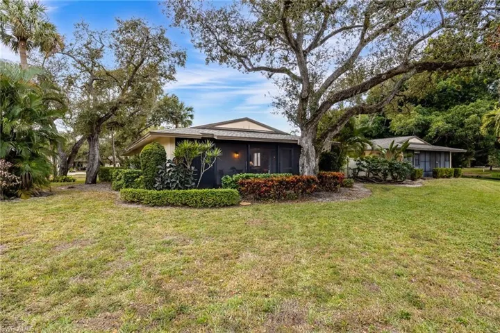 View of property exterior with a yard, a sunroom, and stucco siding