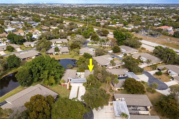 Aerial view of property and surrounding area featuring nearby suburban area and a nearby body of water