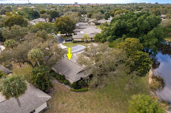 Aerial view of property's location featuring a large body of water and a tree filled landscape
