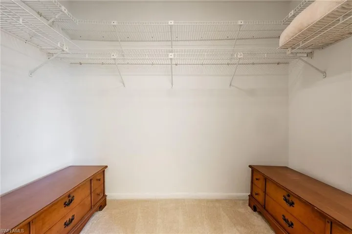 Walk in closet featuring light carpet