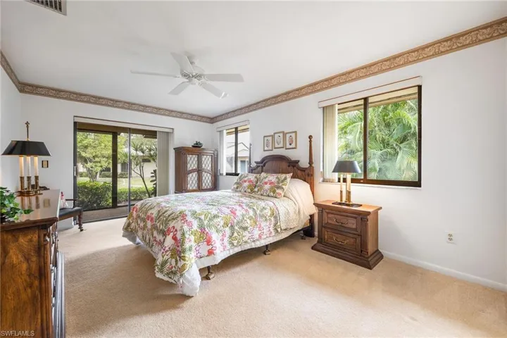 Bedroom featuring carpet floors, multiple windows, and ceiling fan