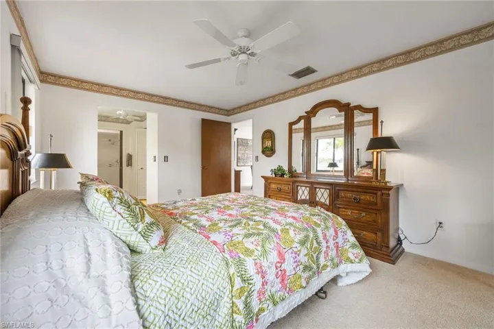 Bedroom with light colored carpet and a ceiling fan