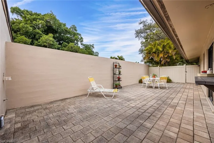 Fenced backyard featuring a patio, outdoor dining space, and a gate