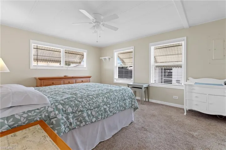Bedroom featuring baseboards, a ceiling fan, and carpet
