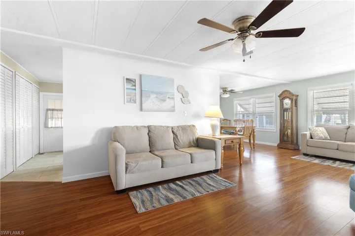 Living area with baseboards, ceiling fan, and wood finished floors