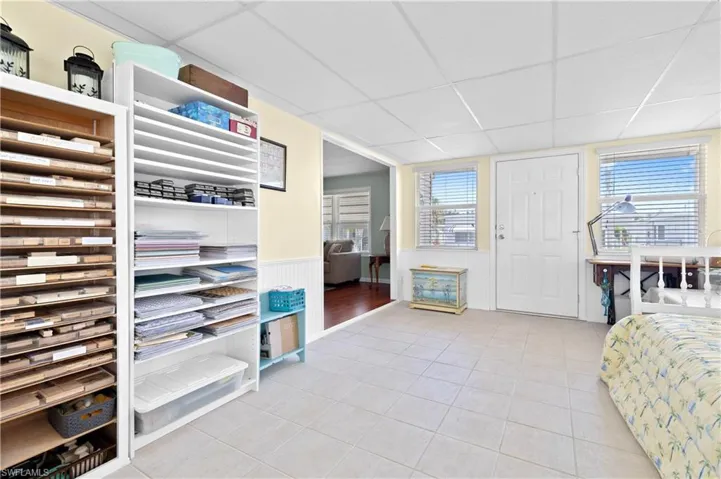 Bonus room featuring a wainscoted wall, light tile patterned floors, and a paneled ceiling