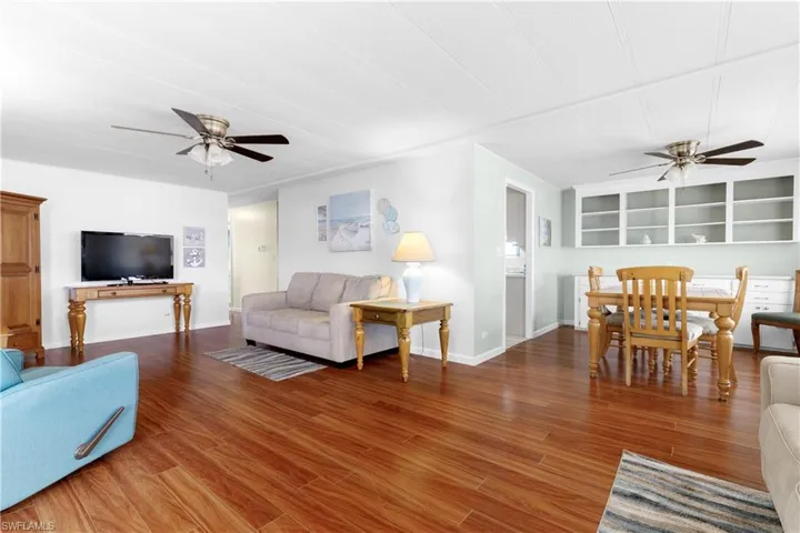 Living room with baseboards, wood finished floors, and a ceiling fan