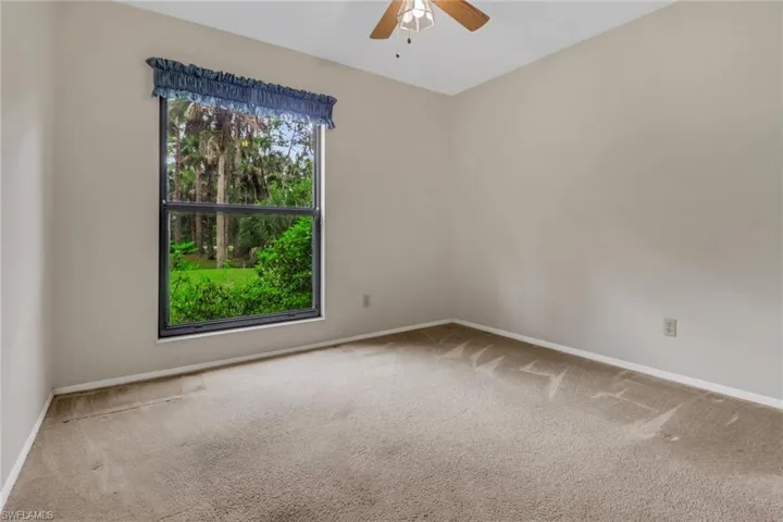 Carpeted spare room with ceiling fan