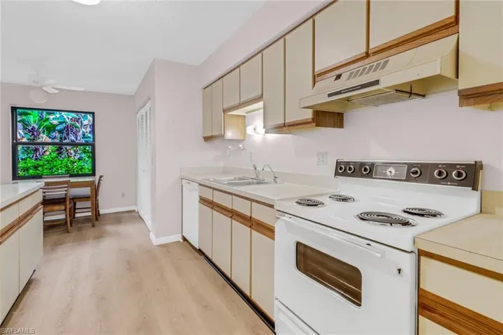 Kitchen featuring white appliances, sink, light hardwood / wood-style floors, custom exhaust hood, and ceiling fan