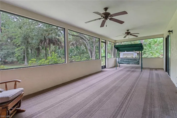 Unfurnished sunroom with a wealth of natural light and ceiling fan