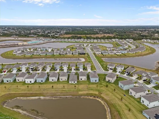 Aerial view of property and surrounding area with nearby suburban area and a large body of water