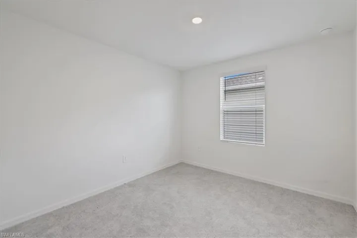 Unfurnished room with light colored carpet and baseboards