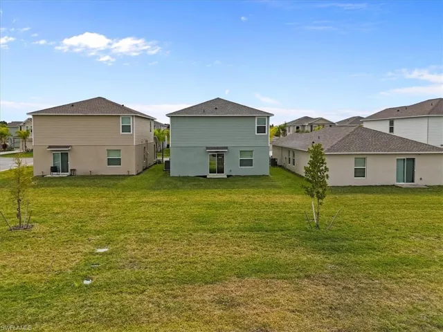 Rear view of property with a lawn and a residential view