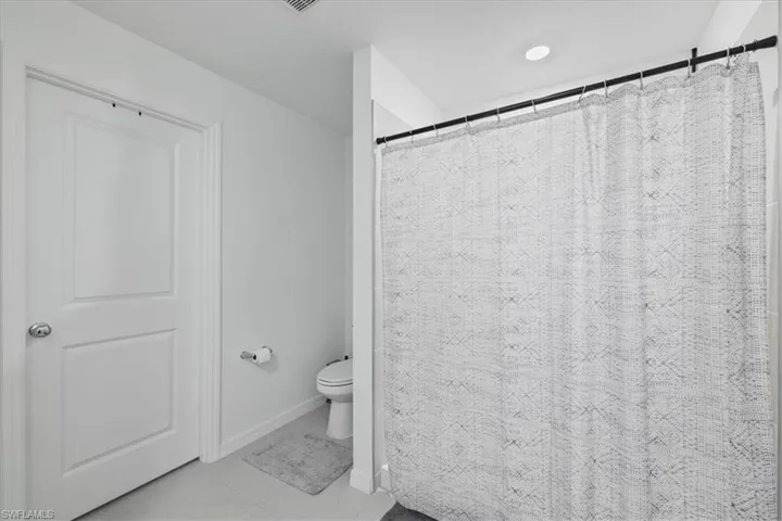 Full bathroom featuring a shower with curtain and light tile patterned flooring