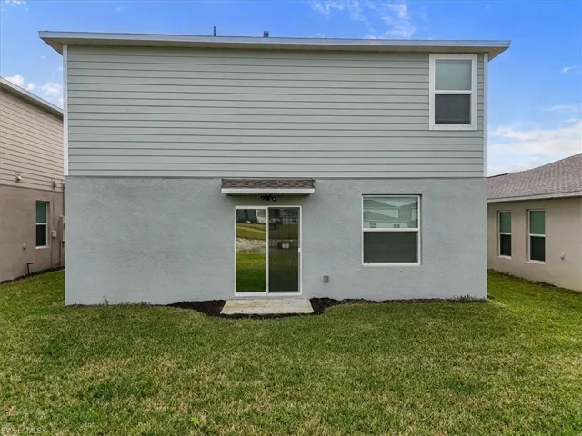 Rear view of property with a lawn