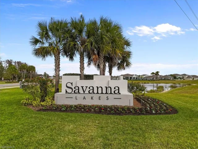 Community sign with a yard, a water view, and a residential view