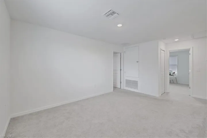 Unfurnished room with light colored carpet and recessed lighting
