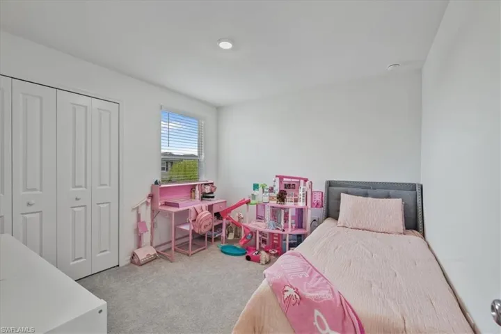 Bedroom with light carpet and a closet