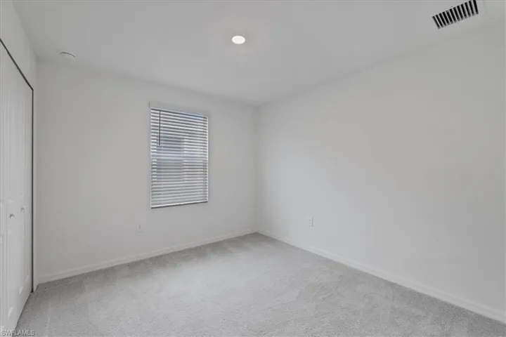 Unfurnished bedroom with a closet and light carpet
