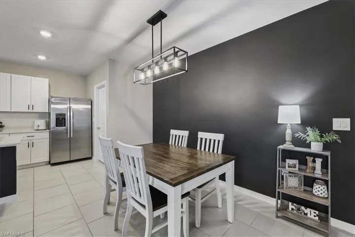 Dining space with light tile patterned flooring and recessed lighting