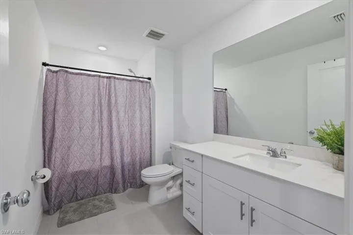 Full bathroom with a shower with curtain, vanity, and light tile patterned floors