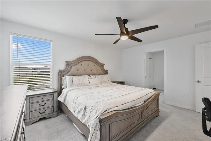 Bedroom featuring light carpet and a ceiling fan
