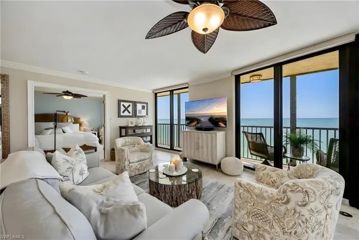 Living area with ceiling fan, floor to ceiling windows, and ornamental molding