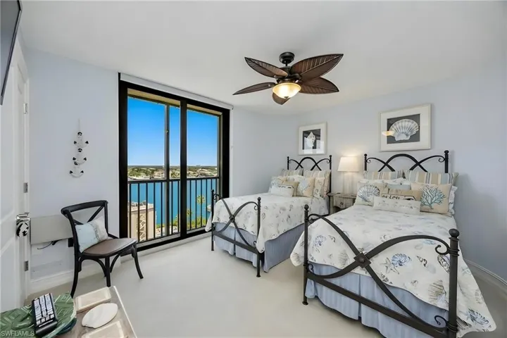 Bedroom with a water view, access to exterior, a ceiling fan, and carpet floors