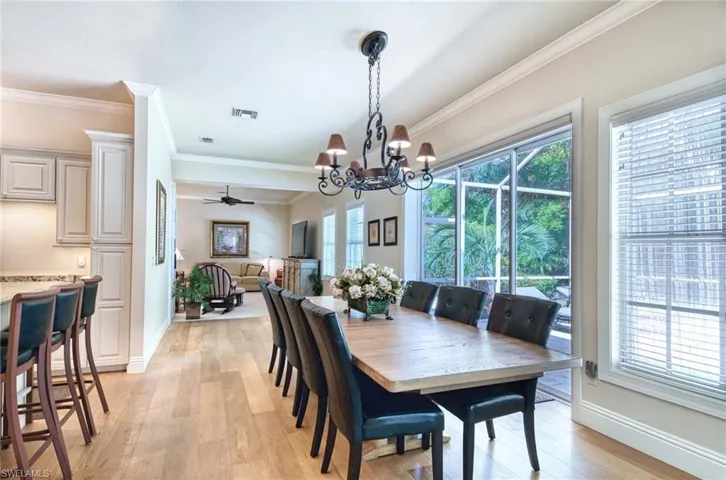 Dining area featuring hardwood flooring, notable chandelier, and crown molding