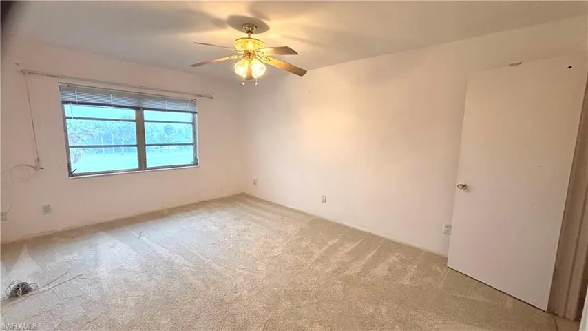 Guest bedroom with ceiling fan and new carpet.