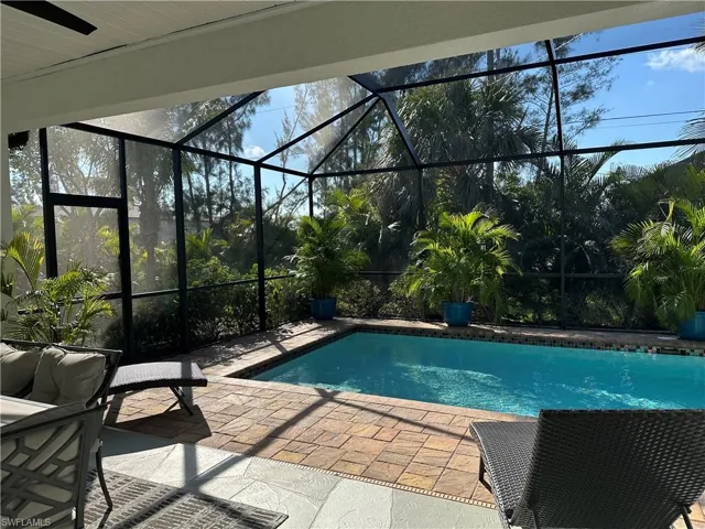 View of pool with a patio and glass enclosure