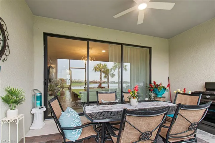 View of patio featuring ceiling fan, outdoor dining space, a water view, and a grill