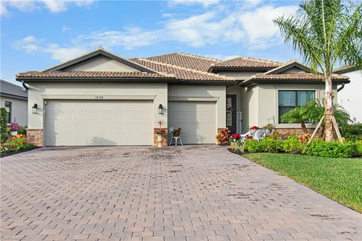 View of front of house featuring stucco siding, decorative driveway, and a garage