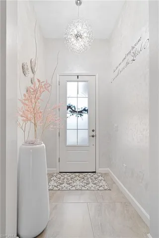 Entryway with a chandelier and baseboards
