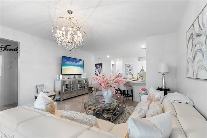 Living room featuring a chandelier and baseboards