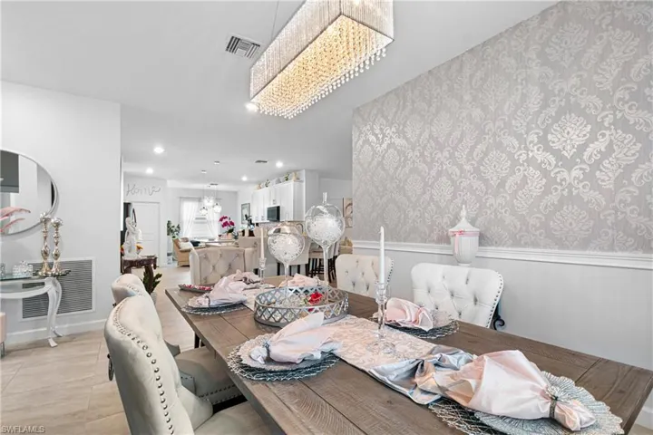 Dining room with a wainscoted wall, a chandelier, recessed lighting, and wallpapered walls