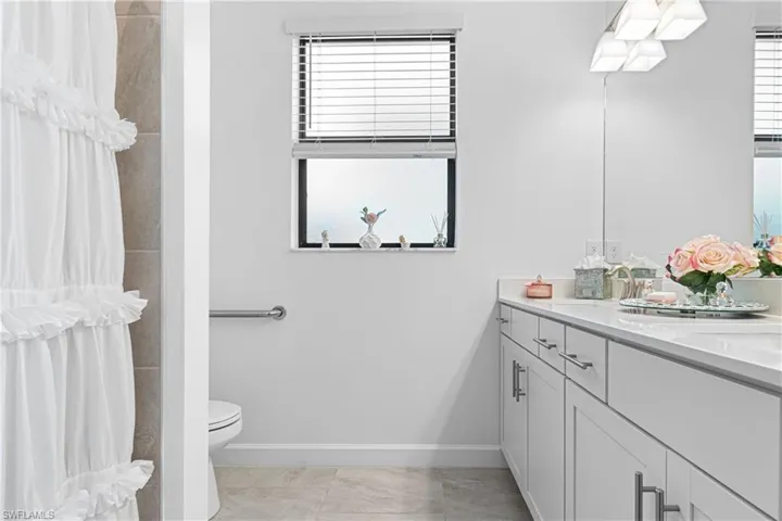 Full bathroom featuring vanity, curtained shower, and tile patterned flooring