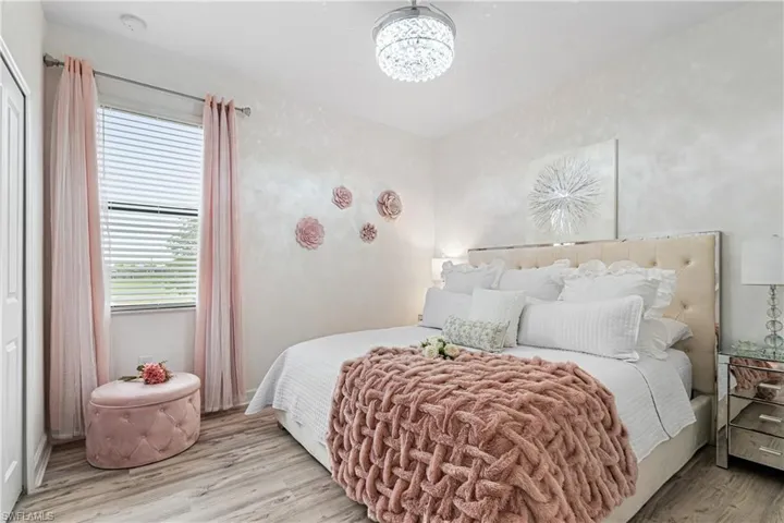 Bedroom featuring wood finished floors and a chandelier